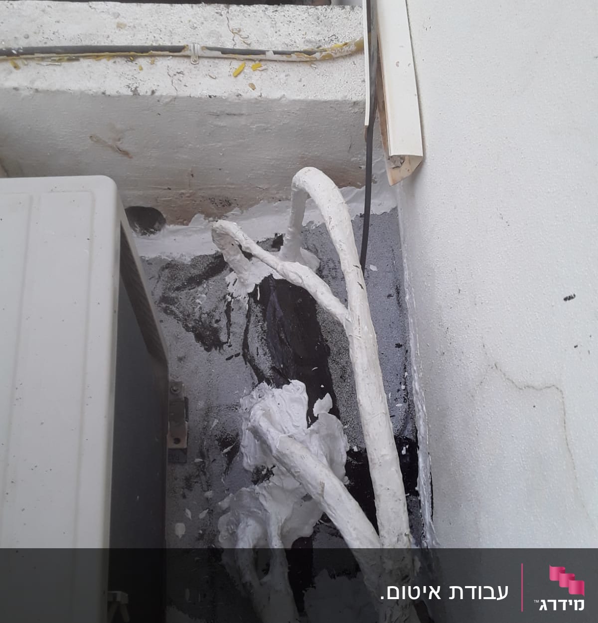 צינורות אטומים בחומר לבן ליד קיר